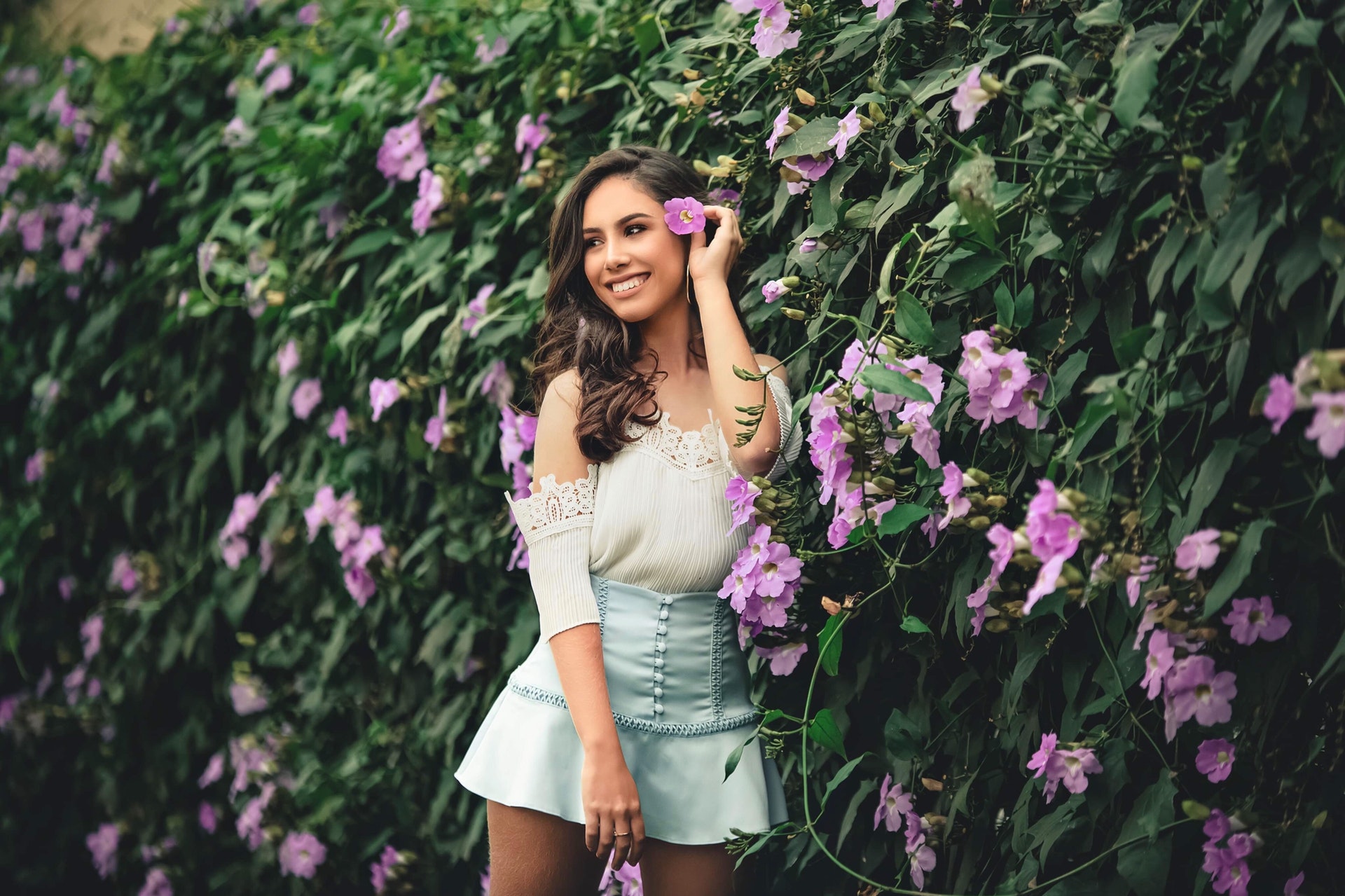 beautiful lady in front of purple flowers in beauty blog